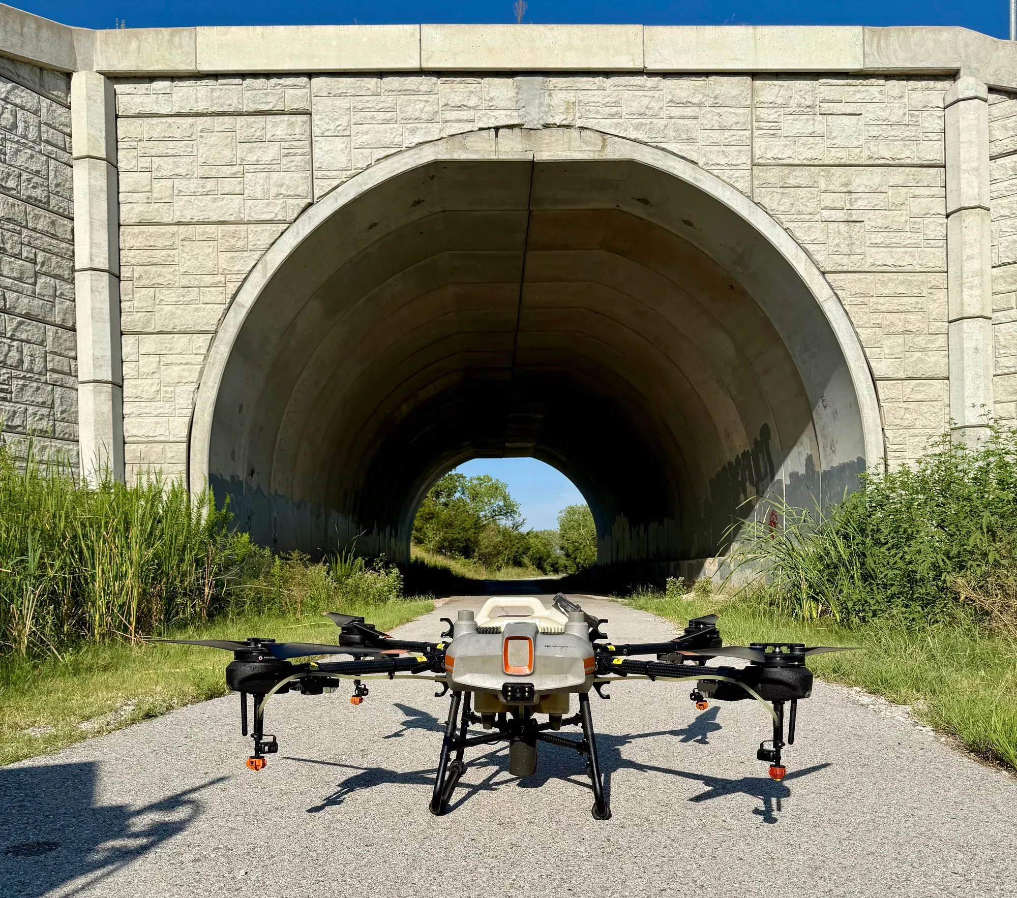 Shuterra’s application drone on a paved access road in front of a concrete arch