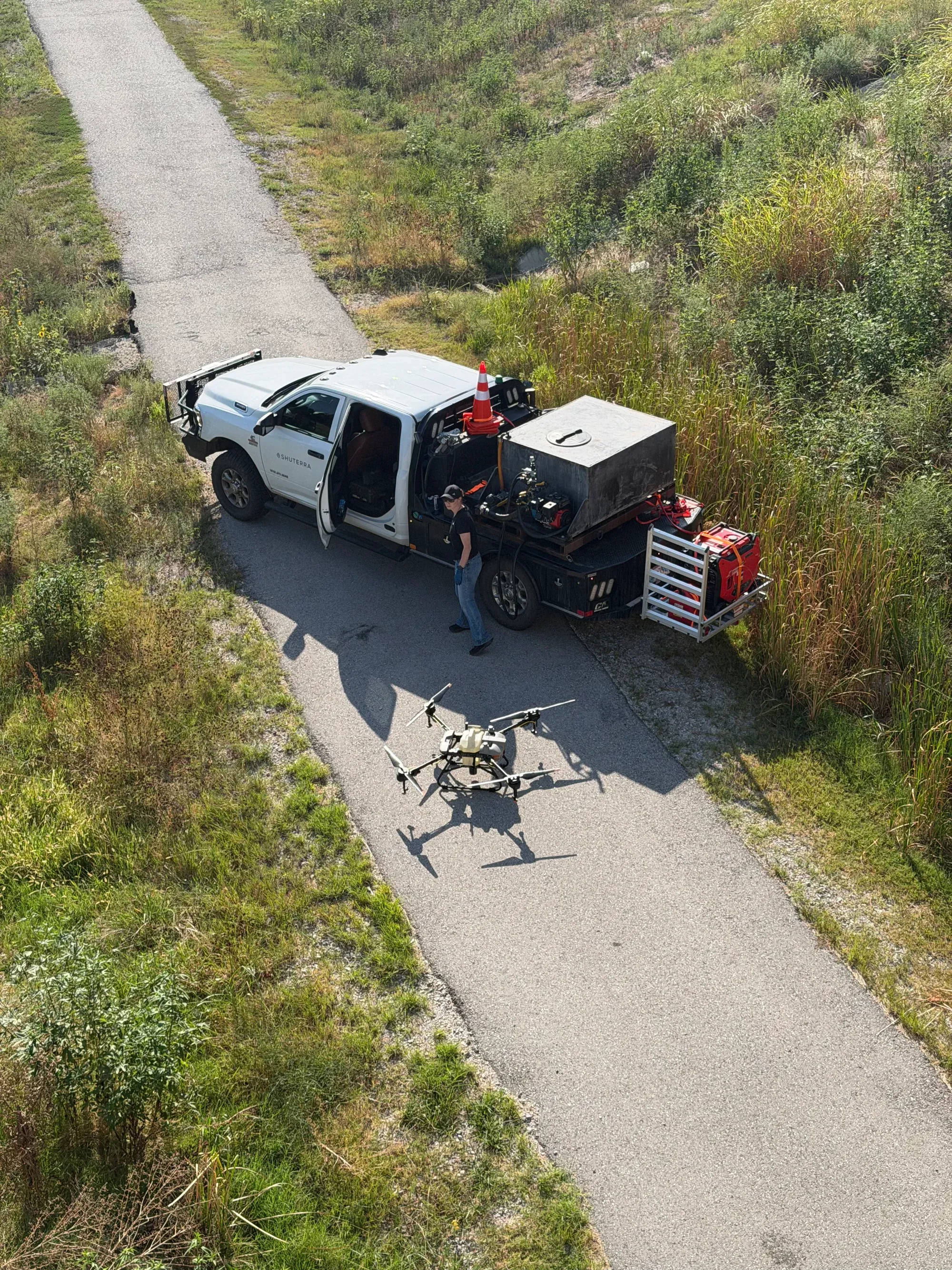 Overhead view of a Shuterra team member beside the support truck and application drone